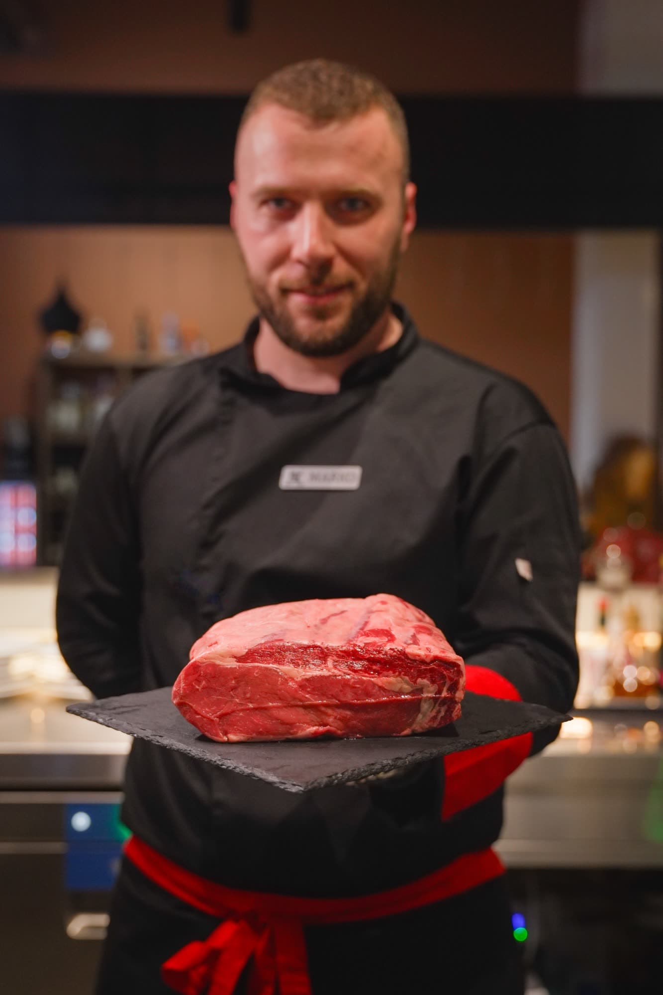 Chef Marko presenting raw aged beef on slate board