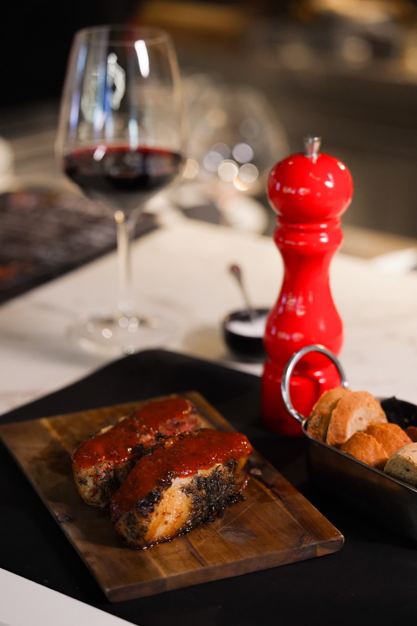 Premium steak on wooden board with red wine in moody lighting